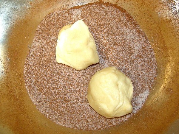 Roll cookie dough in sugar/cinnamon mixture to coat.