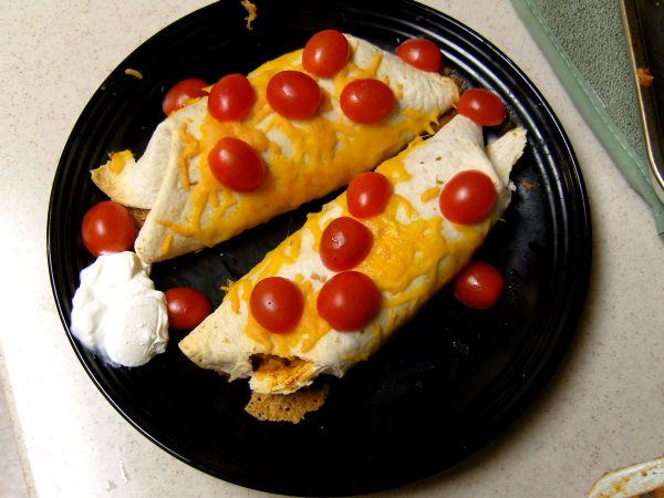 Serve, topped with tomatoes and sour cream (and guacamole if you have it).