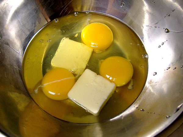 Put eggs in bowl with butter. Leave yolks unbroken.