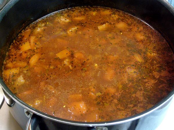 Add tomato sauce, wine and water.  Cook for about an hour.  Stirring occasionally - removing fat fro