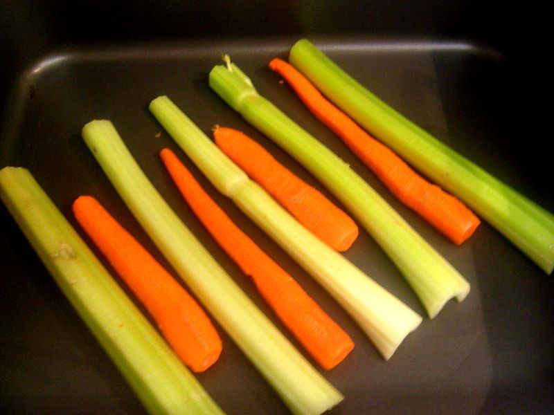 Optional: Lay out celery and carrots to raise the chicken up