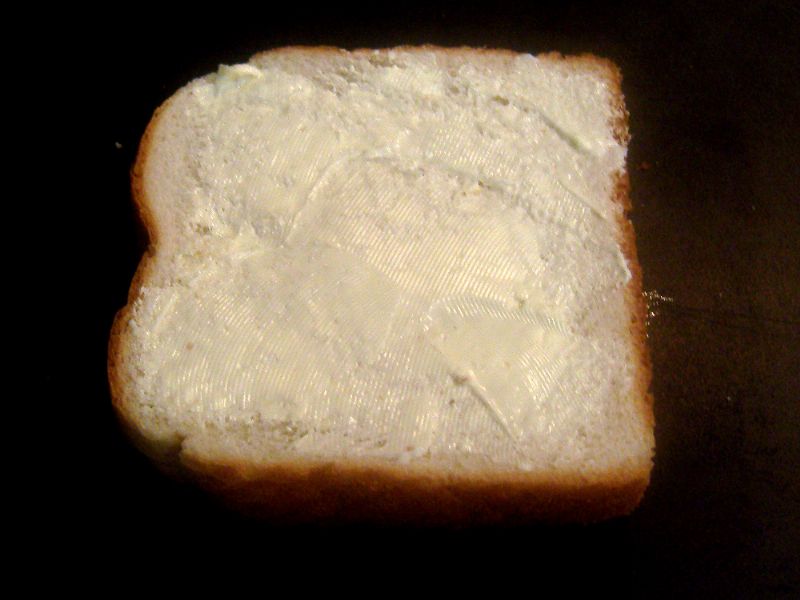 Butter bread on both sides and place on skillet