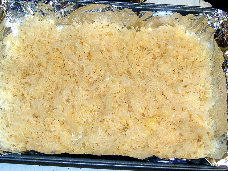Strain, drain and rinse sauerkraut and place in pan.