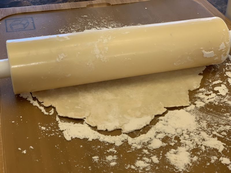 Roll out a ball of dough flat.