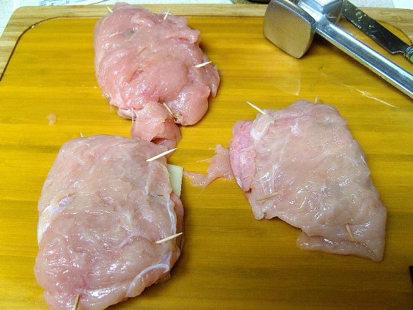 Use toothpicks to fold chicken together.